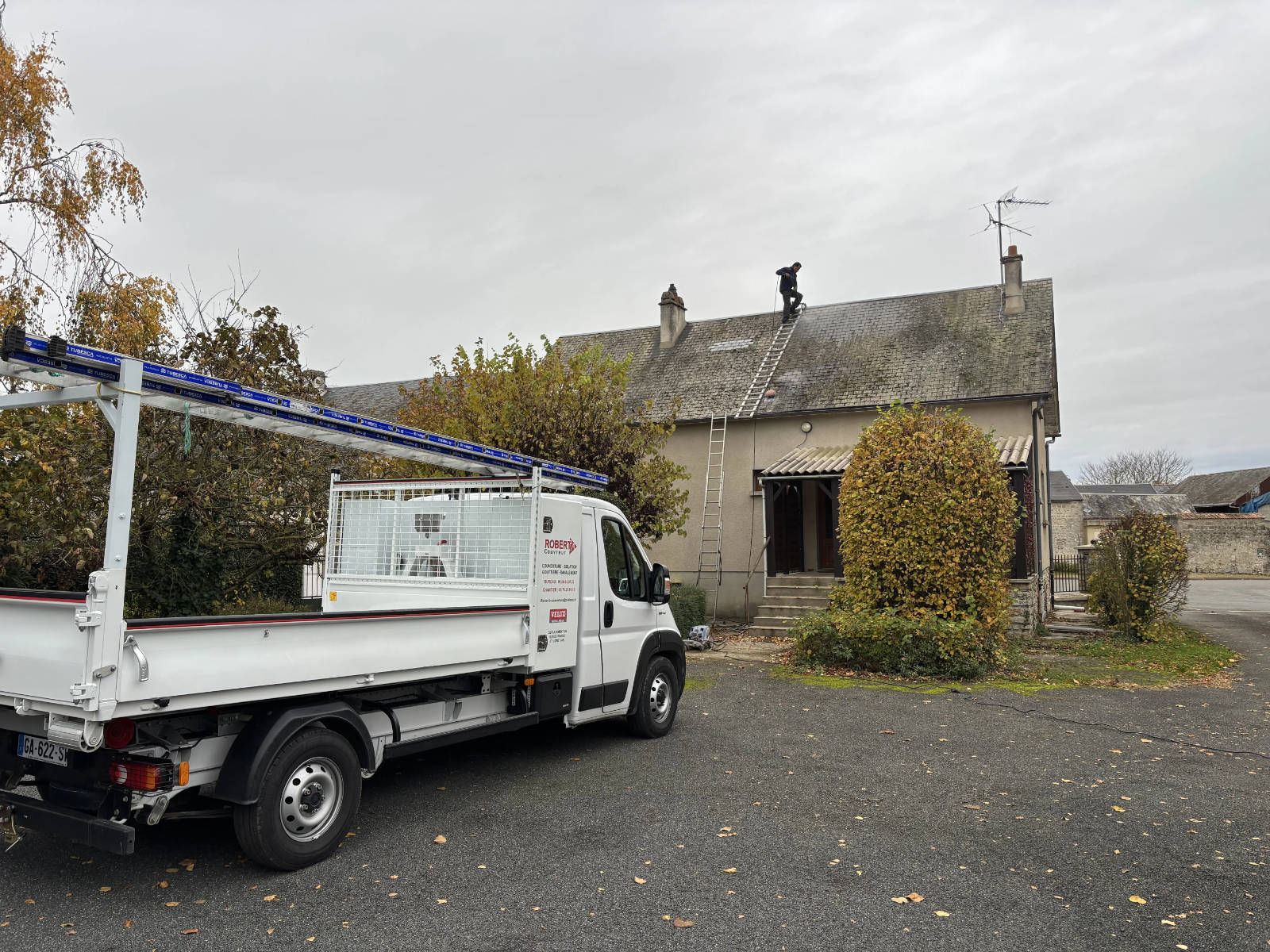 Camion Robert B. Couvreur garé devant une maison dans le Val-de-Marne pendant un chantier de nettoyage de toiture